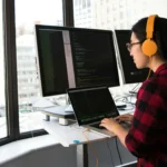 moça fazendo programação em um dos notebooks para programar