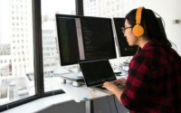 moça fazendo programação em um dos notebooks para programar