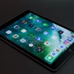 tablet da samsung em cima de uma mesa ligado com os aplicativos aparecendo na tela