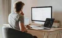 moço olhando para computador com uma página aberta de códigos ilustrando a hospedagem de sites linux