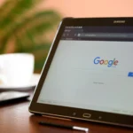 tablet samsung galaxy em cima de uma mesa ao lado de celular e uma xícara
