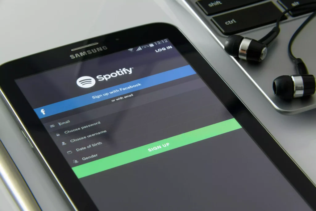 Tablet Samsung sobre mesa ao lado de fone de ouvido com fio