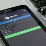 Tablet Samsung sobre mesa ao lado de fone de ouvido com fio