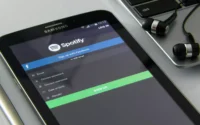 Tablet Samsung sobre mesa ao lado de fone de ouvido com fio