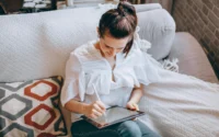moça sentada no sofá usando um tablet da xiaomi com uma caneta digital