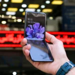 mão de moço segurando um celular que dobra