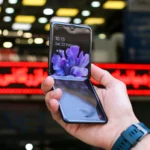mão de pessoa segurando um celular dobrável