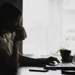 moça tomando café e usando notebook ilustrando o tema de comprar computador